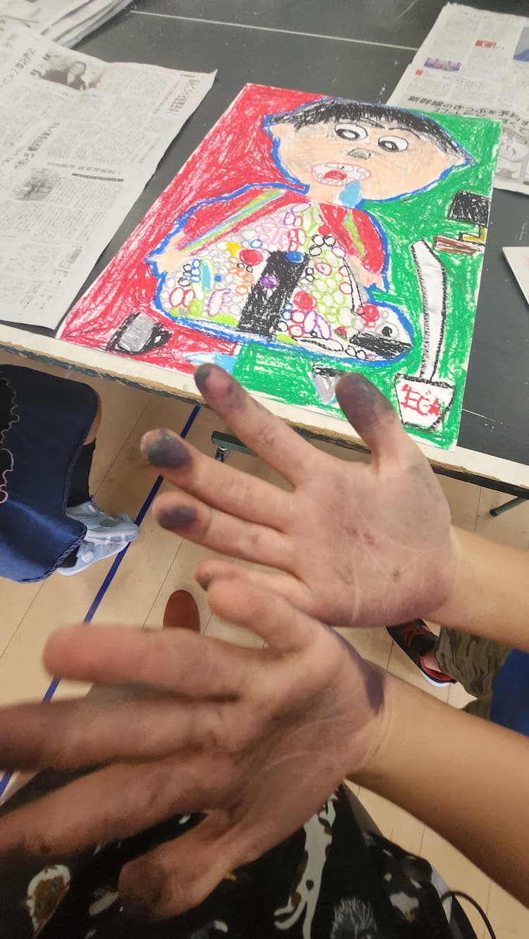 絵の具で汚れた手と作品